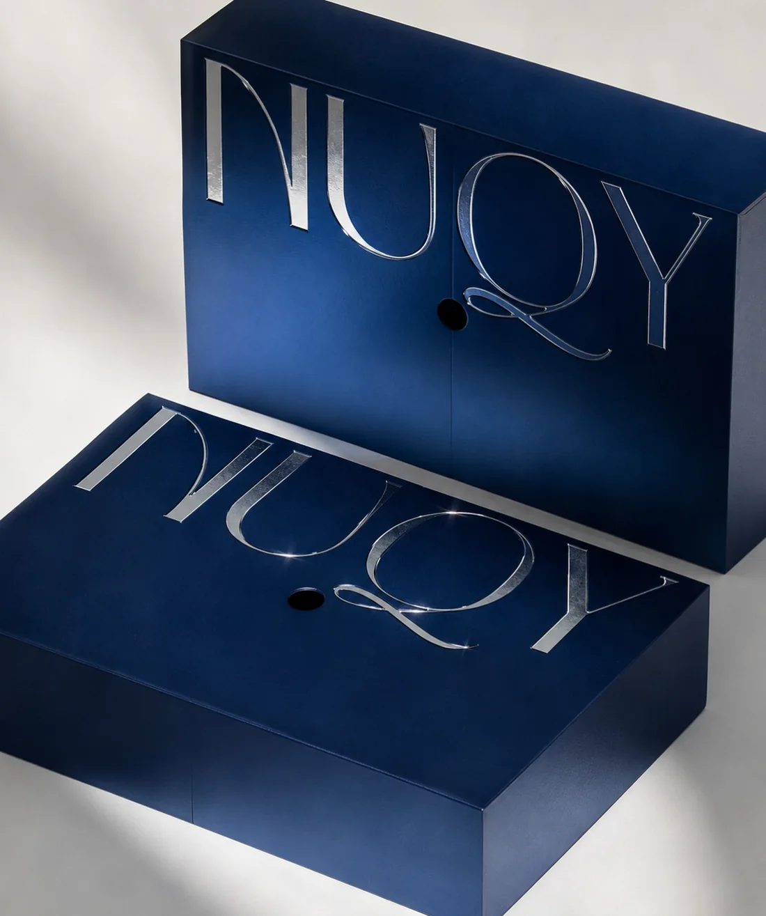 Estuches rígidos en azul marino con tipografía aplicada en foil metálico